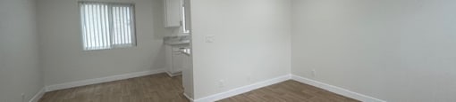 A room with wooden flooring and white walls.