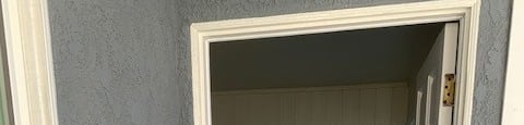 A white door with a window above it in a room.