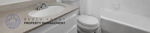 A white bathroom with a sink, toilet, and bathtub.