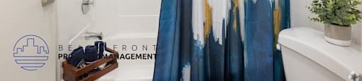 A shower curtain with blue and gold paint splatter design.