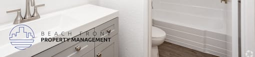 A white bathroom with a sink, mirror, and toilet.