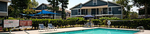 A swimming pool in a residential area with a house in the background.