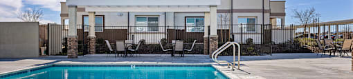 A large house with a pool in front.