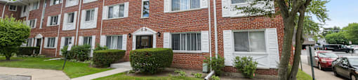 a brick apartment building with a sidewalk in front of it