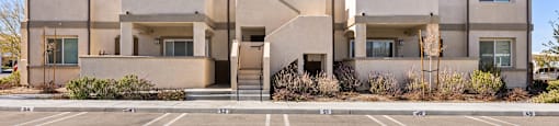A large apartment building with a parking lot in front.