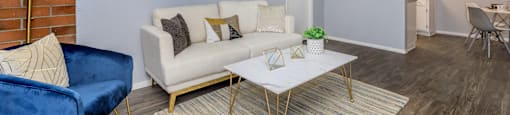 A living room with a blue chair and a white couch.