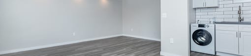 an empty living room with a washer and dryer in it