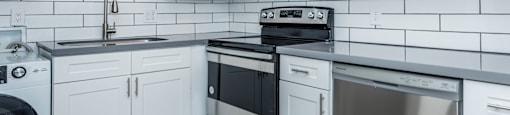 a kitchen with white cabinets and stainless steel appliances