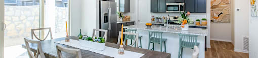 A modern kitchen with a dining table and chairs.