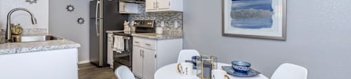 A kitchen with a table and chairs in the middle of the room.