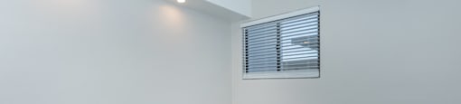 an empty room with white walls and a window