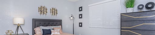 A bedroom with a bed, nightstand, and dresser.