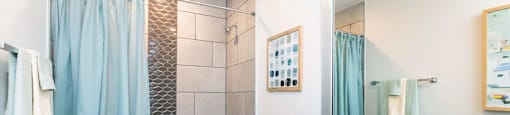A bathroom with a white toilet, a sink, and a shower with a blue curtain.