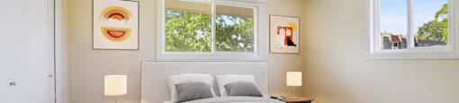 a bedroom with a bed and two windows