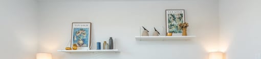 Two desks with chairs and shelves with decorative items.