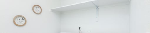 Two white front loading washing machines in a laundry room.