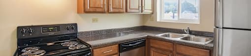a kitchen with wooden cabinets and stainless steel appliances and a window
