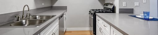 A kitchen with a sink, stove, and microwave.