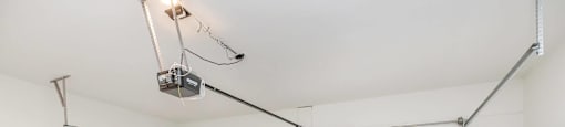 A white garage door is closed and there is a light on the ceiling.