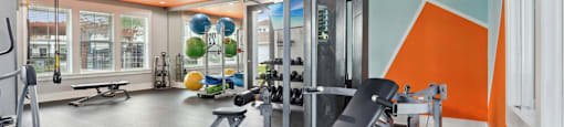 A gym with orange and blue walls and a variety of equipment.