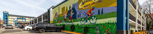 a mural on the side of a building in a parking lot
