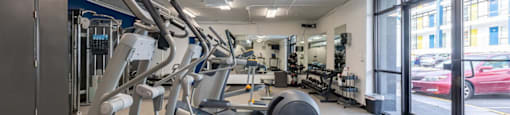a gym with weights and cardio equipment in the lobby of a building
