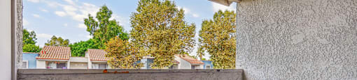 A balcony with a view of houses and trees.