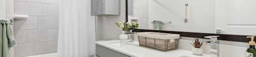 A bathroom with a white toilet, a white sink, and a white bathtub with a white shower curtain.