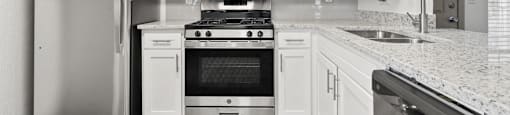 A kitchen with white cabinets and stainless steel appliances.