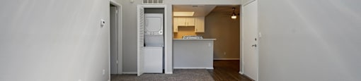 A white room with a fridge and a window.