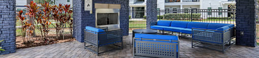 A patio with a grill and seating area.