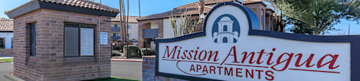 A sign for Mission Antigua Apartments is displayed in front of a building.