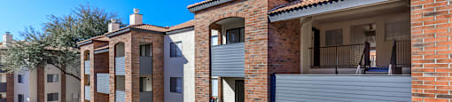 A row of modern brick houses with balconies and staircases.