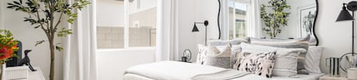 A bedroom with a large bed and a mirror on the wall.