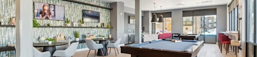 A room with a pool table and a TV mounted on the wall.