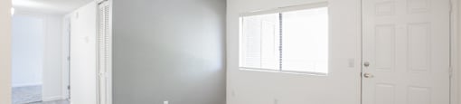 A room with a grey wall and a white door.