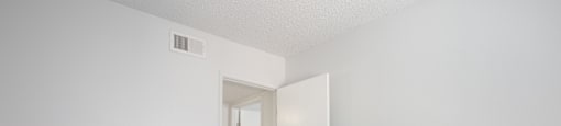 A room with a carpeted floor and a white door.