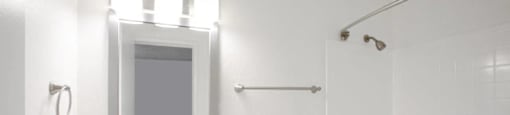 A white bathroom with a sink, toilet, and shower.