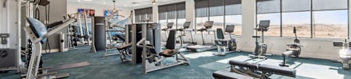 A gym with a view of the desert outside the window.