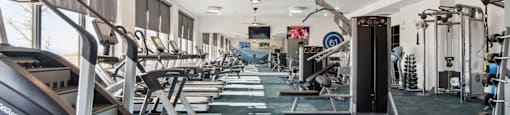 A gym with treadmills, weights, and exercise equipment.