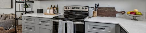 A modern kitchen with a stainless steel oven and white cabinets.