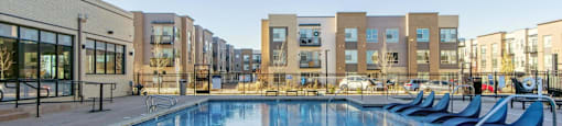 A swimming pool in front of apartment buildings.