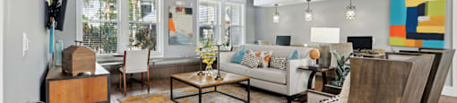 A living room with a white couch and a wooden chair.