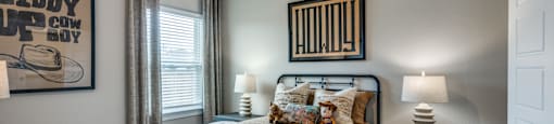 A bedroom with a bed, nightstand, and a poster on the wall.