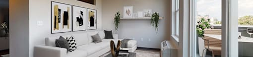 A modern living room with a white couch and a glass coffee table.