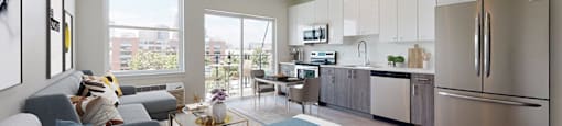 A modern kitchen with stainless steel appliances and a dining area with a glass table.