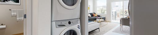 A modern laundry room with a washer and dryer stacked on top of each other.