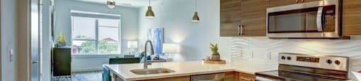 kitchen appliances with brown cabinets at Brixton South Shore, Austin, 78741