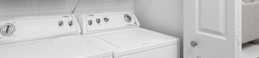 A white washing machine and dryer in a laundry room.