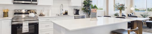 A modern kitchen with white cabinets and a large island.